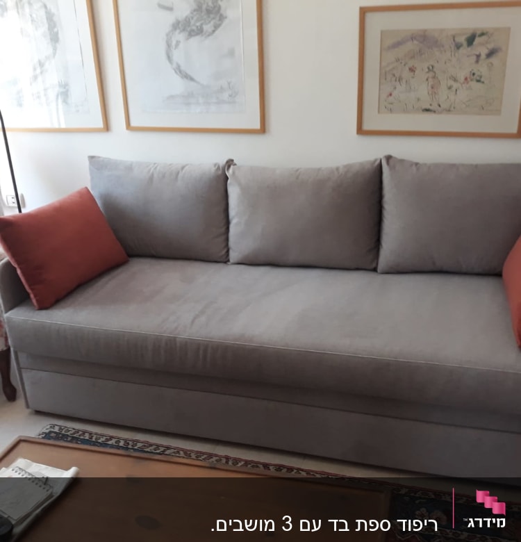 ספה אפורה עם כריות כתומות על משענות